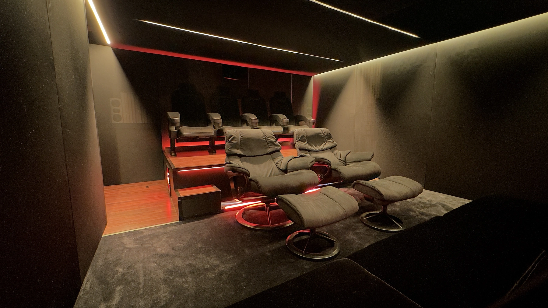 Seitliche Akustikwand mit indirektem Licht, Lounge-Sesseln und Podest