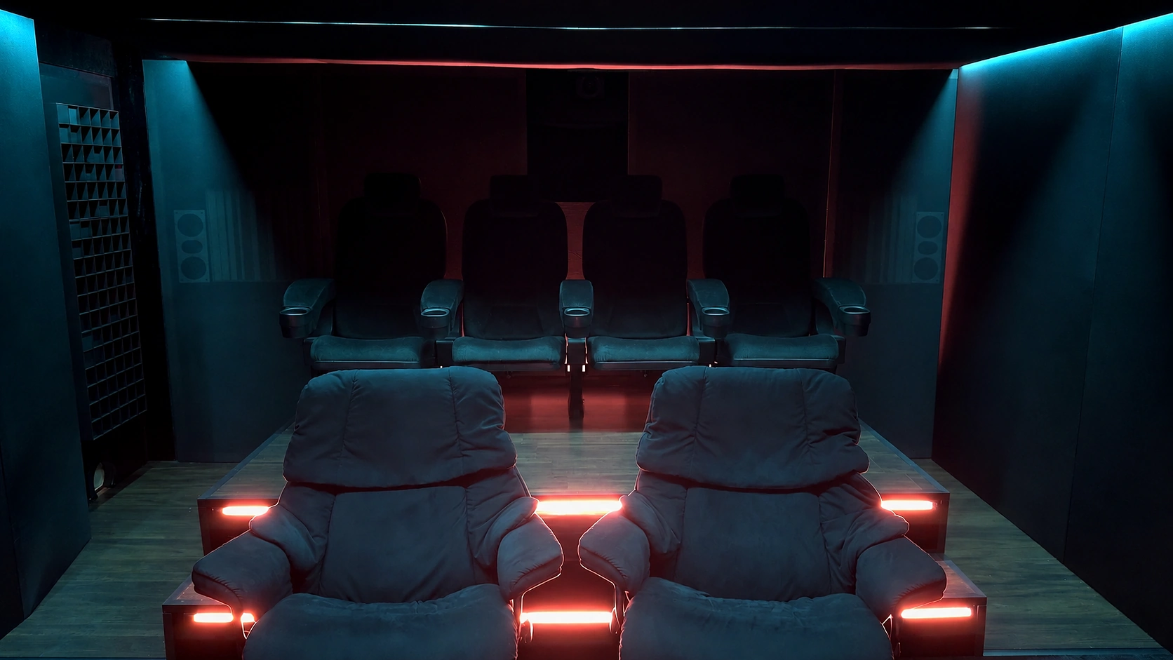 Blick in das eclipse Heimkino mit Lounge-Sesseln, Podest und farbiger Lichtstimmung